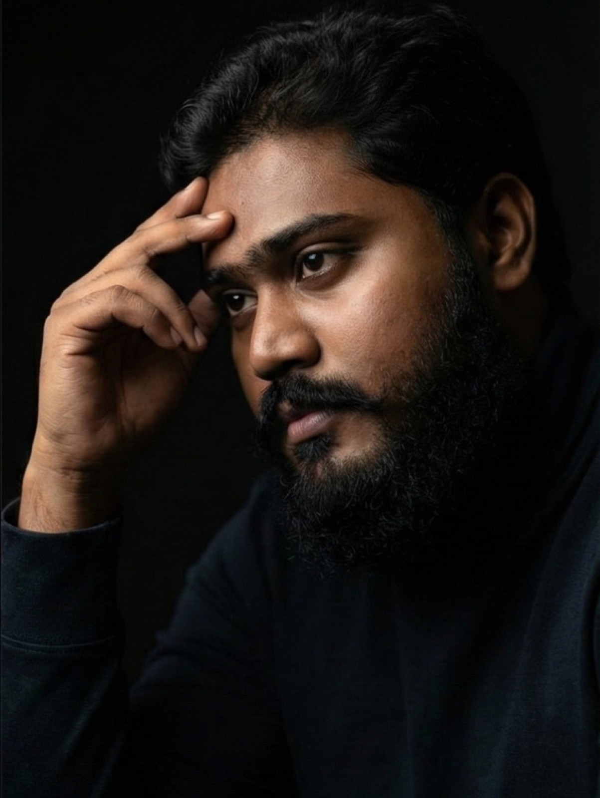thrinadhsai thoughtful author portrait in dark studio